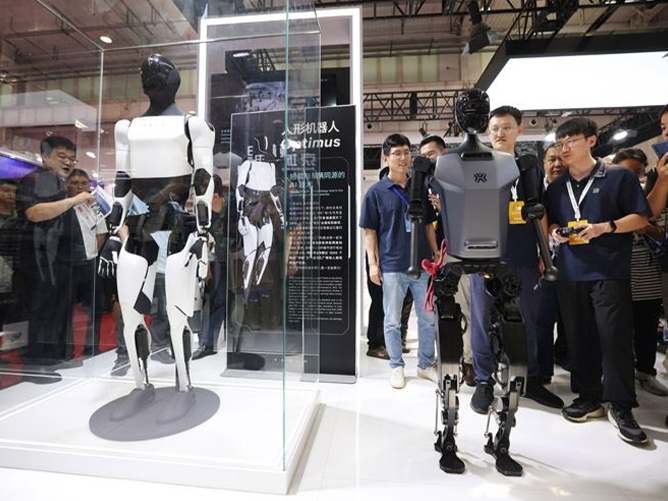 Exhibition floor at the 2025 IEEE-RAS International Conference on Humanoid Robots in Seoul, showing attendees observing advanced humanoid robots on display behind glass panels.